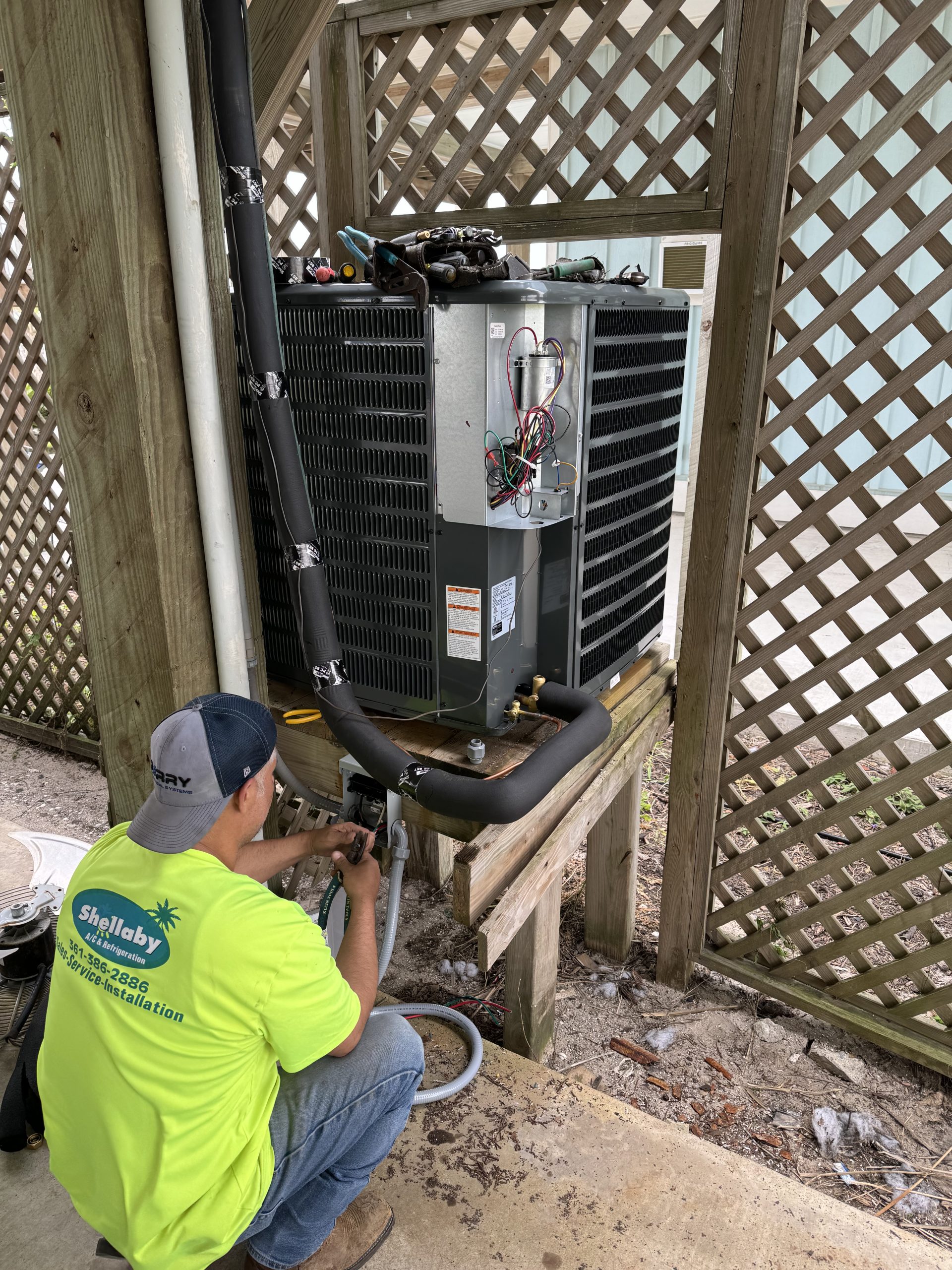 Shellaby technician repairing an outdoor air conditioning system